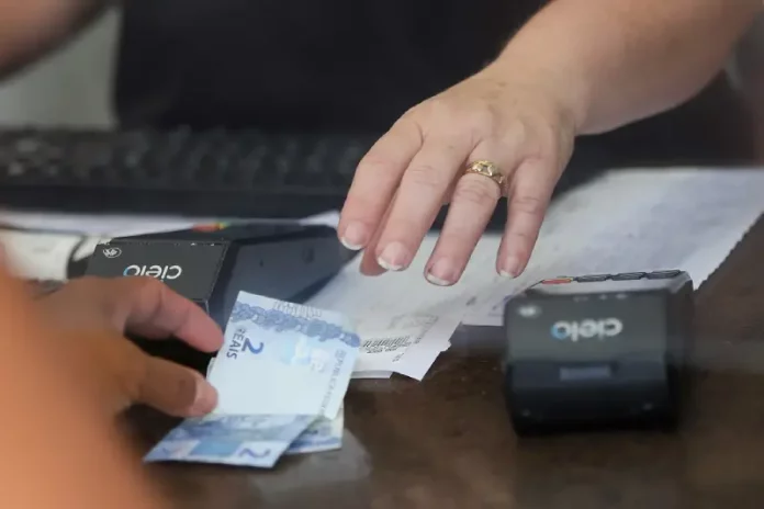 Pessoa realiza pagamento em estabelecimento comercial, imagem usada para ilustrar a liberdade econômica e o ambiente de negócios.