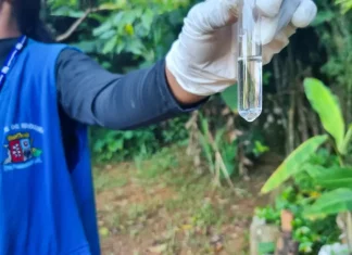 Agente de combate às endemias coleta amostra de água durante ação de fiscalização para prevenir focos do mosquito da dengue.