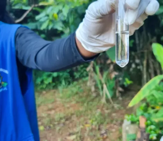 Agente de combate às endemias coleta amostra de água durante ação de fiscalização para prevenir focos do mosquito da dengue.