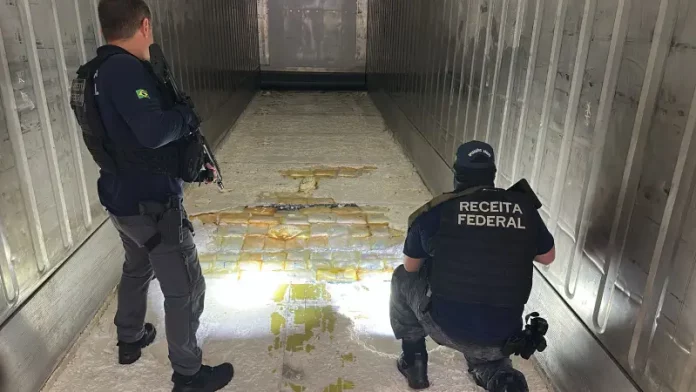 Agentes da Receita Federal vistoriam carga de maconha apreendida em caminhão