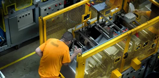 Trabalho prisional em SC gera R$ 32 milhões em 2025 e reduz gastos do Estado Detento operando uma máquina em unidade prisional, ilustrando o programa de trabalho remunerado de presos em Santa Catarina.