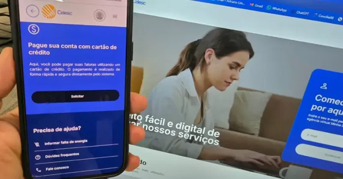 Aplicativo da Celesc exibido em um celular mostra a opção de pagamento da conta de luz com cartão de crédito, enquanto ao fundo aparece a Agência Web da companhia, ilustrando os canais digitais disponíveis para os clientes.