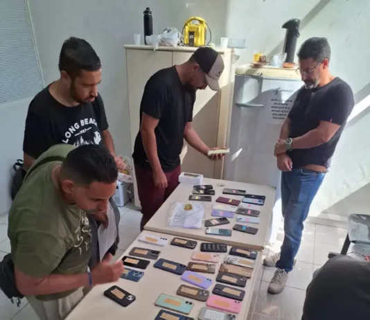 Pessoas fazendo o reconhecimento dos celulares furtados durante o carnaval