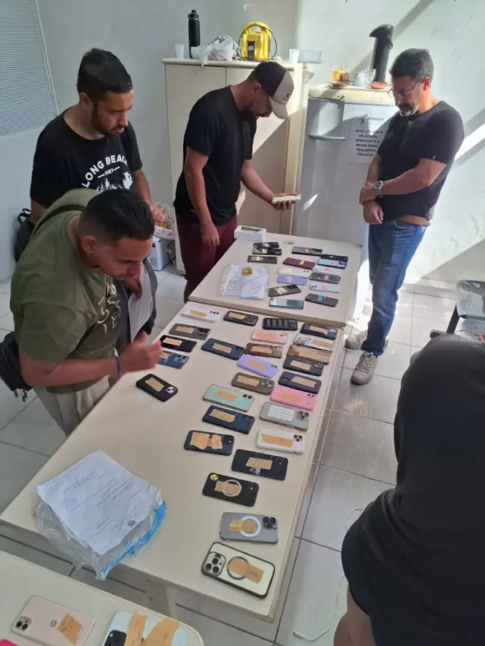 Pessoas fazendo o reconhecimento dos celulares furtados durante o carnaval