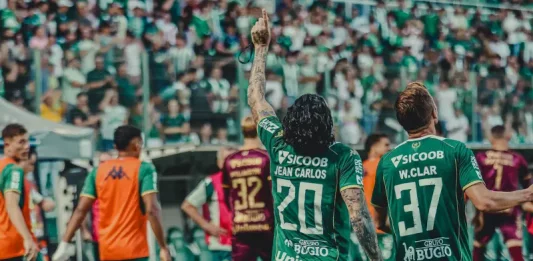 Jogadores da Chapecoense comemoram em campo após vitória no Campeonato Catarinense, com a torcida ao fundo na Arena Condá.