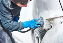 Homem utilizando lixadeira para preparar carro, simbolizando participante do curso gratuito de funilaria e pintura em São José