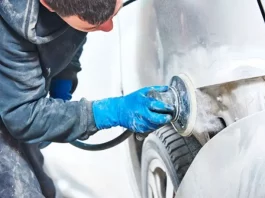 Homem utilizando lixadeira para preparar carro, simbolizando participante do curso gratuito de funilaria e pintura em São José