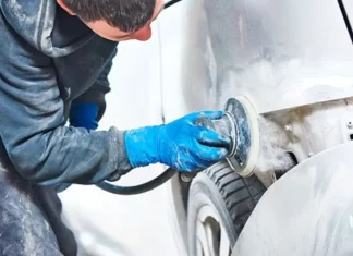 Homem utilizando lixadeira para preparar carro, simbolizando participante do curso gratuito de funilaria e pintura em São José