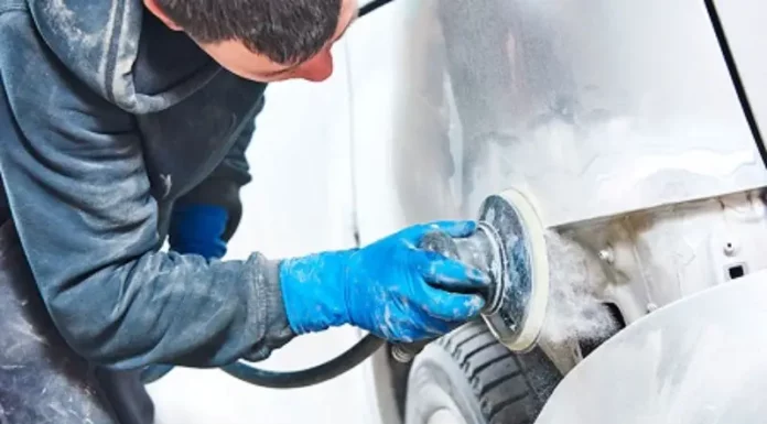 Homem utilizando lixadeira para preparar carro, simbolizando participante do curso gratuito de funilaria e pintura em São José
