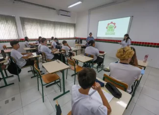 Estudantes assistem aula de cursos técnicos gratuitos em sala de escola pública, com professores orientando a formação profissional e a preparação para o mercado de trabalho.