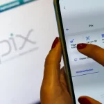 Novas regras do Pix entram em vigor e reforçam combate a fraudes Pessoa utiliza o aplicativo do Pix em um smartphone, representando as novas regras do Pix voltadas ao reforço da segurança e ao combate a fraudes nas transações financeiras.