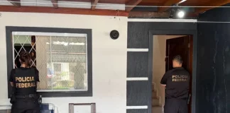 Dois agentes da Polícia Federal cumprem mandados durante operação contra fraudes bancárias SC em residência