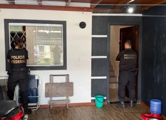 Dois agentes da Polícia Federal cumprem mandados durante operação contra fraudes bancárias SC em residência