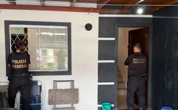 Dois agentes da Polícia Federal cumprem mandados durante operação contra fraudes bancárias SC em residência