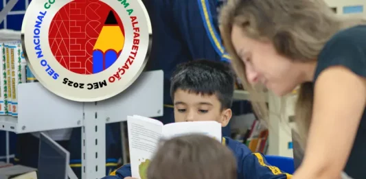 Biguaçu conquista Selo Prata do MEC por avanços na alfabetização Professora acompanhando crianças em alfabetização em Biguaçu