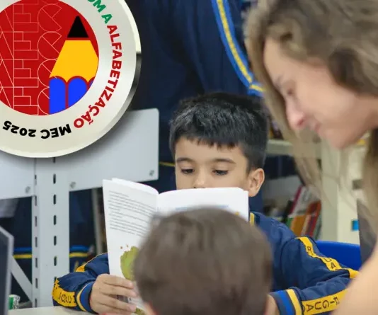 Biguaçu conquista Selo Prata do MEC por avanços na alfabetização Professora acompanhando crianças em alfabetização em Biguaçu