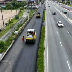 Triplicação da SC-401 chega a 60% e prevê novos viadutos em Florianópolis Obras de triplicação da SC-401 em Florianópolis mostram máquinas asfaltando nova faixa da rodovia, com veículos circulando nas pistas ao lado, evidenciando a ampliação da capacidade de tráfego e a melhoria da mobilidade no acesso ao Norte da Ilha.