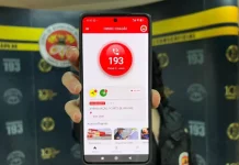 Mão segurando um celular com o aplicativo CBMSC Cidadão aberto, mostrando a opção de ligar para o 193.