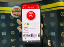 Mão segurando um celular com o aplicativo CBMSC Cidadão aberto, mostrando a opção de ligar para o 193.