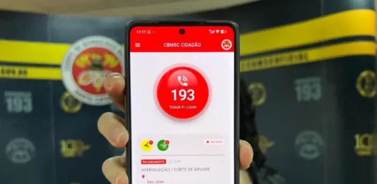 Chamadas para o 193 podem ser realizadas pelo aplicativo CBMSC Cidadão Mão segurando um celular com o aplicativo CBMSC Cidadão aberto, mostrando a opção de ligar para o 193.