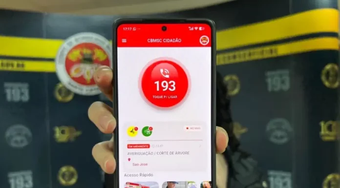 Mão segurando um celular com o aplicativo CBMSC Cidadão aberto, mostrando a opção de ligar para o 193.