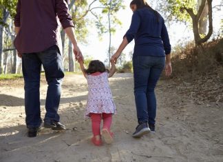 São José reforça planejamento do Serviço de Família Acolhedora Adultos caminham ao ar livre de mãos dadas com uma criança, simbolizando acolhimento familiar, cuidado, proteção e convivência em ambiente seguro.