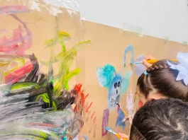 Crianças participam de atividade artística em sala de aula, ilustrando o ambiente educativo da rede municipal e a disponibilidade de vagas na educação infantil.