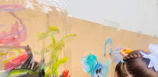 Crianças participam de atividade artística em sala de aula, ilustrando o ambiente educativo da rede municipal e a disponibilidade de vagas na educação infantil.