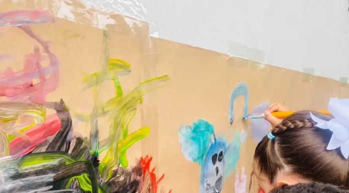 Crianças participam de atividade artística em sala de aula, ilustrando o ambiente educativo da rede municipal e a disponibilidade de vagas na educação infantil.