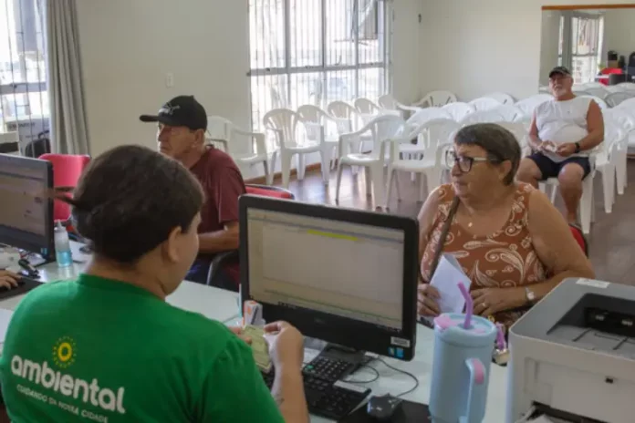 Funcionários da Ambiental atendendo a população para retirada do carnê da tarifa do lixo em São José