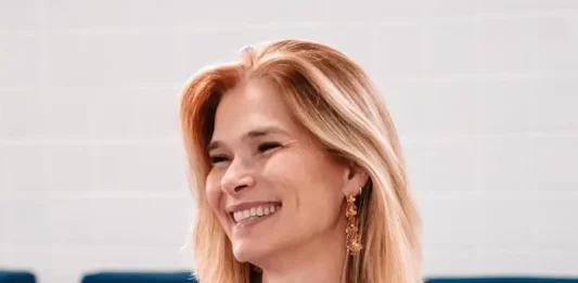 Angela Albino se filia ao PDT e reforça projeto de Gelson Merisio em SC Angela Albino sorrindo, sentada e segurando um celular, durante anúncio de filiação ao PDT em SC