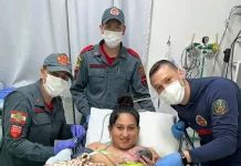 Bombeiros realizam parto em SC: equipe posa com mãe segurando recém-nascido.