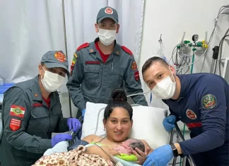 Bombeiros realizam parto em SC: equipe posa com mãe segurando recém-nascido.