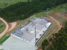 Vista aérea de uma subestação de energia elétrica instalada em área rural de Santa Catarina, cercada por vegetação e estradas de terra. A estrutura, com transformadores, torres e equipamentos de distribuição, representa os investimentos das cooperativas de energia na ampliação e modernização da rede elétrica, garantindo mais segurança energética e qualidade no fornecimento, especialmente para produtores e municípios do interior.