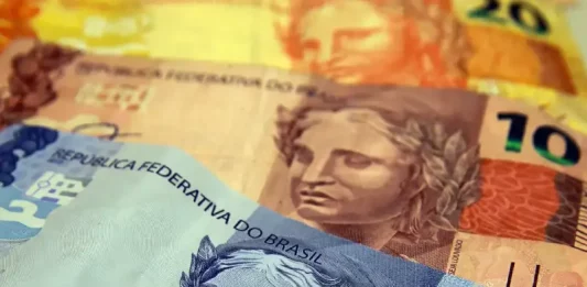 Cédulas de dinheiro simbolizando o pagamento e a restituição do Imposto de Renda 2026.