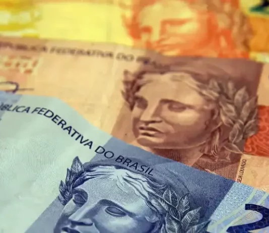 Cédulas de dinheiro simbolizando o pagamento e a restituição do Imposto de Renda 2026.