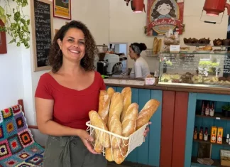 Empresária Leslie Araújo, representando o empreendedorismo feminino em Santa Catarina, segura cesta de pães na Pão da Leli, Florianópolis