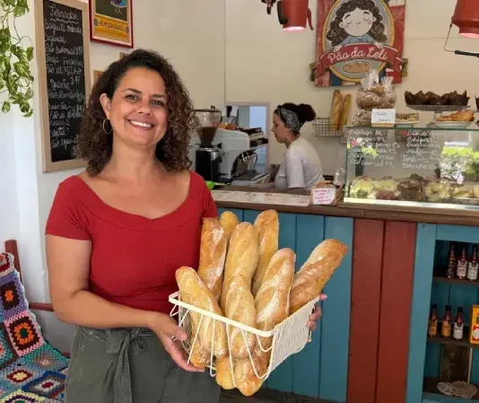 Empresária Leslie Araújo, representando o empreendedorismo feminino em Santa Catarina, segura cesta de pães na Pão da Leli, Florianópolis