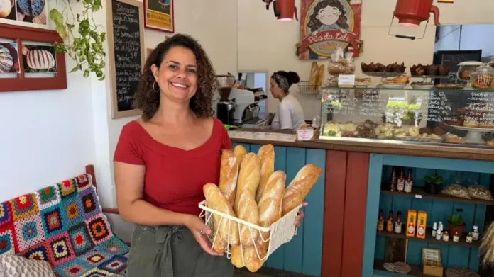 Empreendedorismo feminino em Santa Catarina Empresária Leslie Araújo, representando o empreendedorismo feminino em Santa Catarina, segura cesta de pães na Pão da Leli, Florianópolis