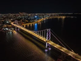 Vista aérea da Ponte Hercílio Luz iluminada à noite durante as comemorações do aniversário de Florianópolis 353 anos