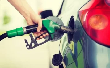 Procon de Florianópolis determina que posto venda gasolina a preço de custo após constatar aumento injustificado Mão segurando bomba de gasolina representando ação do Procon de Florianópolis