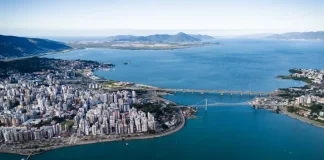 Vista aérea de Florianópolis, com destaque para a área urbana, pontes e o litoral, ilustrando o avanço da cidade em sustentabilidade por meio do programa Florianópolis Lixo Zero.