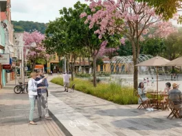 Projeto Floripa Centro propõe planejamento urbano focado nas pessoas Imagem ilustrativa apresenta proposta de requalificação do Centro de Florianópolis, com calçadas amplas, ciclovia, árvores floridas e praça com fonte e mesas ao ar livre. A cena mostra pessoas caminhando, pedalando e convivendo no espaço público, ilustrando a proposta de planejamento urbano que prioriza pedestres, áreas verdes e convivência no projeto Floripa Centro.