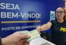 Pessoa receendo a carteira de identidade em um posto de identificação da Polícia Científica