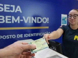 Polícia Científica de SC lança novo site para agendamento da Carteira de Identidade Nacional Pessoa receendo a carteira de identidade em um posto de identificação da Polícia Científica