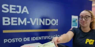 Pessoa receendo a carteira de identidade em um posto de identificação da Polícia Científica