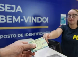 Pessoa receendo a carteira de identidade em um posto de identificação da Polícia Científica