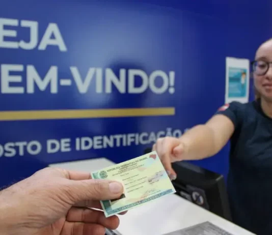 Pessoa receendo a carteira de identidade em um posto de identificação da Polícia Científica