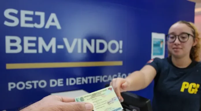 Polícia Científica de SC lança novo site para agendamento da Carteira de Identidade Nacional Pessoa receendo a carteira de identidade em um posto de identificação da Polícia Científica
