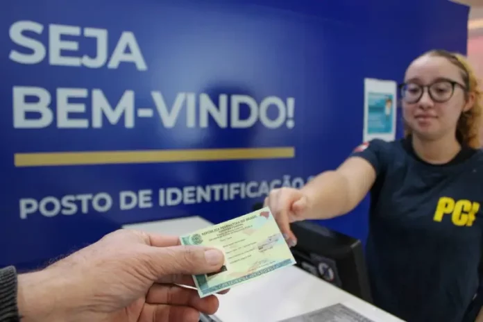 Pessoa receendo a carteira de identidade em um posto de identificação da Polícia Científica